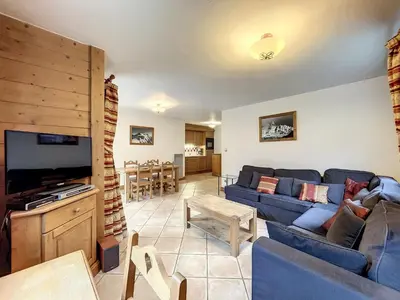 a living room with a blue couch and a tv at Chamonix: Appartement 3 pièces, 6 pers, Parking - FR-1-507-76 in Chamonix-Mont-Blanc