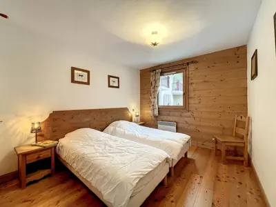 a bedroom with a bed and a wooden wall at Chamonix: Appartement 3 pièces, 6 pers, Parking - FR-1-507-76 in Chamonix-Mont-Blanc
