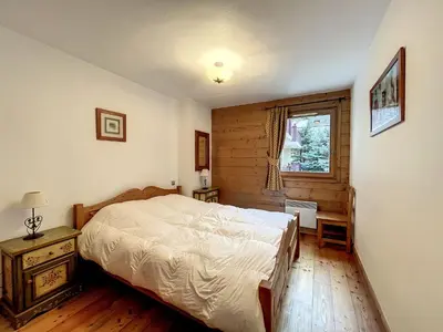 a bedroom with a bed and a window at Chamonix: Appartement 3 pièces, 6 pers, Parking - FR-1-507-76 in Chamonix-Mont-Blanc