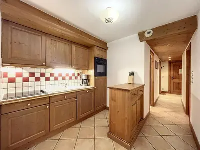 a large kitchen with wooden cabinets and a sink at Chamonix: Appartement 3 pièces, 6 pers, Parking - FR-1-507-76 in Chamonix-Mont-Blanc