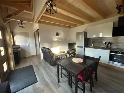 a kitchen and living room with a table and chairs at La Tanière in Samoëns