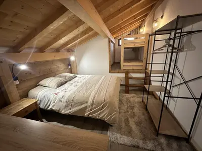 a small bedroom with a bed and a ladder at La Tanière in Samoëns