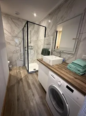a bathroom with a washing machine and a sink at La Tanière in Samoëns