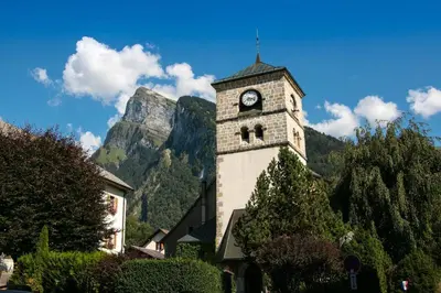 a building with a clock tower in front of a mountain at La Tanière in Samoëns