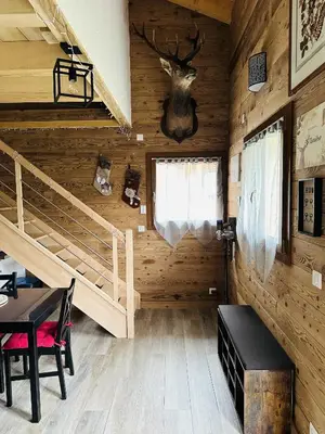 a log cabin with a bunk bed and a table and chairs at La Tanière in Samoëns