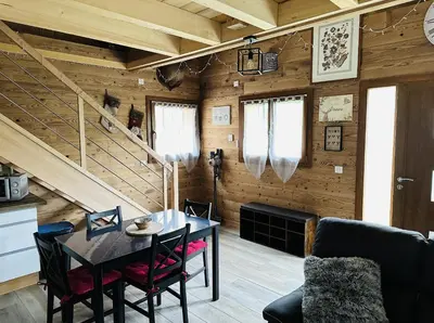 a dining room with a table and a staircase at La Tanière in Samoëns