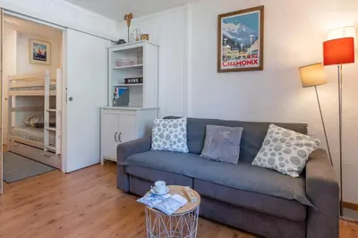 a living room with a couch and a bunk bed at Cosy studio with view of Brévent in Chamonix-Mont-Blanc