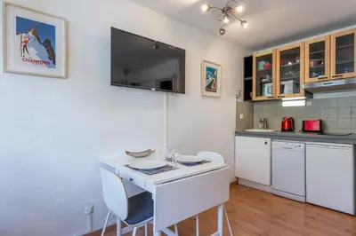 a kitchen with a small white table and chairs at Cosy studio with view of Brévent in Chamonix-Mont-Blanc