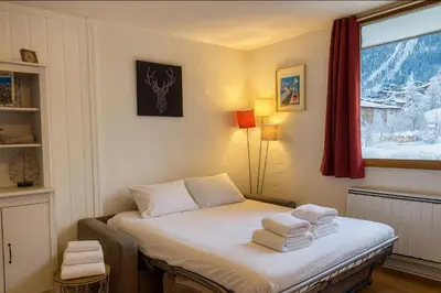 a small room with a bed with towels on it at Cosy studio with view of Brévent in Chamonix-Mont-Blanc