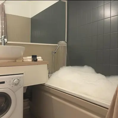 a bathroom with a washing machine and a mirror at Cosy studio with view of Brévent in Chamonix-Mont-Blanc