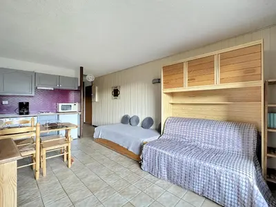 a hotel room with a bed and a kitchen at MOU2E Studio 4 Pers centre des Carroz in Les Carroz d'Araches