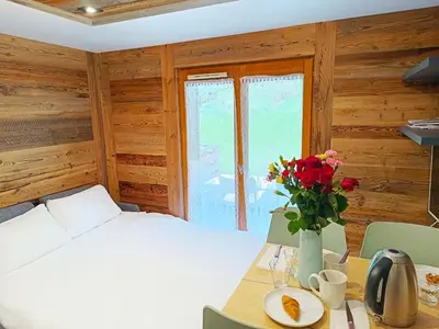 a bedroom with a bed and a table with a vase of flowers at Le Cocon Des Pistes in Saint-Gervais-les-Bains