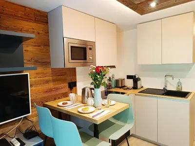 a kitchen with a table with chairs and a microwave at Le Cocon Des Pistes in Saint-Gervais-les-Bains