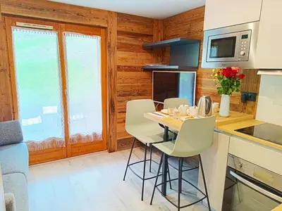 a kitchen with a table and chairs in a room at Le Cocon Des Pistes in Saint-Gervais-les-Bains