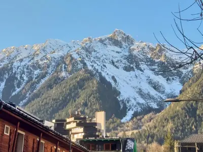 a snow covered mountain in front of a city at Chez moi in Chamonix-Mont-Blanc