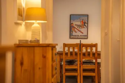 a dining room with a table and two chairs and a lamp at 3 bed apt,central location, parking, garden, 6 pax in Saint-Gervais-les-Bains