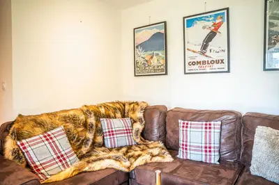 a brown leather couch with a blanket on it at 3 bed apt,central location, parking, garden, 6 pax in Saint-Gervais-les-Bains