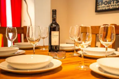 a bottle of wine sitting on a table with glasses at 3 bed apt,central location, parking, garden, 6 pax in Saint-Gervais-les-Bains