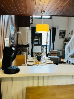 a kitchen and living room with a white counter top at Duplex Le géant 7 voyageurs in Chamonix-Mont-Blanc