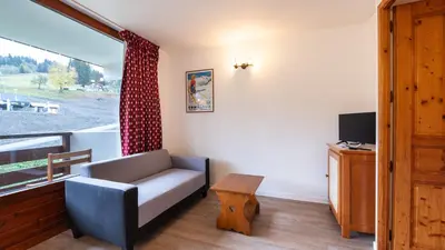 a living room with a couch and a window at Les Eterlous 28 - Appt montagne 4 pers in Morillon