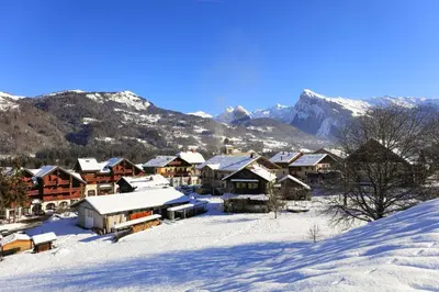 a village covered in snow with mountains in the background at Les Eterlous 28 - Appt montagne 4 pers in Morillon