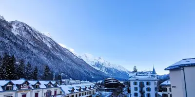 a town covered in snow in front of a mountain at Appartement Chamonix Centre - Vue Mont Blanc in Chamonix-Mont-Blanc
