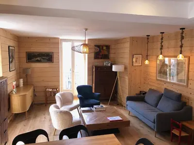 a living room with a blue couch and chairs at Appartement Chamonix Centre - Vue Mont Blanc in Chamonix-Mont-Blanc