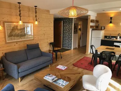 a living room with a couch and a table at Appartement Chamonix Centre - Vue Mont Blanc in Chamonix-Mont-Blanc