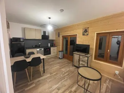 a kitchen with a table and chairs in a room at Résidence La Ruche-Appartement ISOARD (T2) in Les Carroz d'Araches