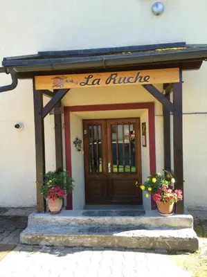 a entrance to a building with two pots of flowers at Résidence La Ruche-Appartement ISOARD (T2) in Les Carroz d'Araches
