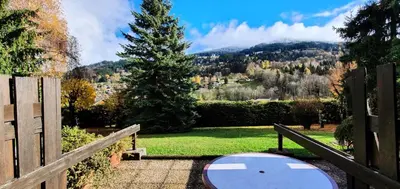 a bench in a garden with a view of a mountain at Résidence Les Coralines Bat A - Coralines A3 MAE-0314 in Megève