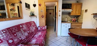 a living room with a red couch and a kitchen at Résidence Les Coralines Bat A - Coralines A3 MAE-0314 in Megève