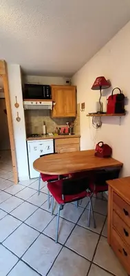 a kitchen with a wooden table and red chairs at Résidence Les Coralines Bat A - Coralines A3 MAE-0314 in Megève
