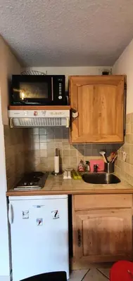 a kitchen with a microwave and a white refrigerator at Résidence Les Coralines Bat A - Coralines A3 MAE-0314 in Megève