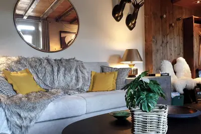 a living room with a couch and a mirror at Tatiana I in Megève