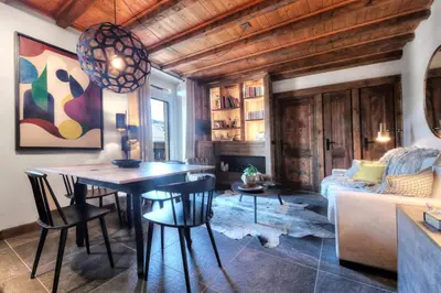 a living room with a table and chairs and a couch at Tatiana I in Megève