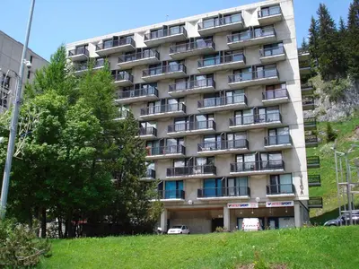 a large apartment building on a hill next to a tree at Studio rénové à Flaine, proche des pistes et commerces - FR-1-425-207 in Arâches-la-Frasse