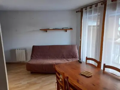 a living room with a couch and a wooden table at Les contamines Montjoie 1 CHAMBRE 4 personnes in Les Contamines-Montjoie