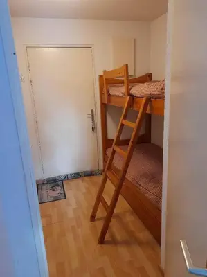a room with two bunk beds and a door at Les contamines Montjoie 1 CHAMBRE 4 personnes in Les Contamines-Montjoie