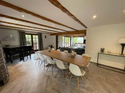 a dining room with a long table and a piano at Chalet de la buche croisée in Combloux