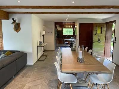 a dining room with a wooden table and chairs at Chalet de la buche croisée in Combloux