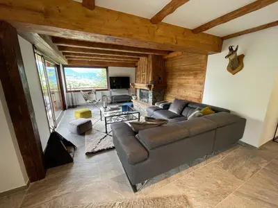a living room with a couch and a table at Chalet de la buche croisée in Combloux