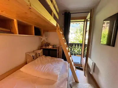 a small bedroom with a bunk bed and a ladder at Grand T3 familial au cœur de Samoëns avec parking et wifi - FR-1-624-148 in Samoëns