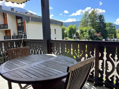 a wooden table and two chairs on a balcony at Grand T3 familial au cœur de Samoëns avec parking et wifi - FR-1-624-148 in Samoëns