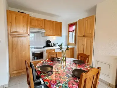 a kitchen with a table with chairs and a table sidx sidx sidx at Grand T3 familial au cœur de Samoëns avec parking et wifi - FR-1-624-148 in Samoëns