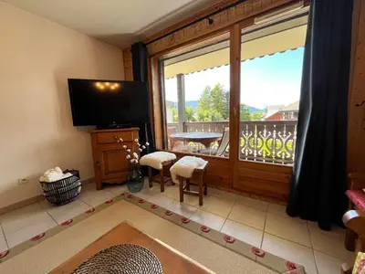 a living room with a large window and a television at Grand T3 familial au cœur de Samoëns avec parking et wifi - FR-1-624-148 in Samoëns
