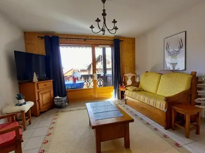 a bedroom with a bed and a tv and a table at Grand T3 familial au cœur de Samoëns avec parking et wifi - FR-1-624-148 in Samoëns