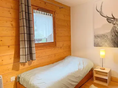 a bedroom with a bed and a window at Appartement T3 avec balcon et grande terrasse, proche centre et ski-bus, parking inclus - FR-1-624-149 in Samoëns