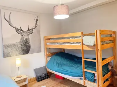a bedroom with bunk beds with a deer painting on the wall at Appartement T3 avec balcon et grande terrasse, proche centre et ski-bus, parking inclus - FR-1-624-149 in Samoëns