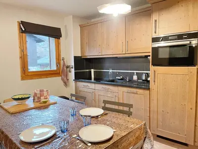 a kitchen with a table with plates on it at Appartement T3 avec balcon et grande terrasse, proche centre et ski-bus, parking inclus - FR-1-624-149 in Samoëns